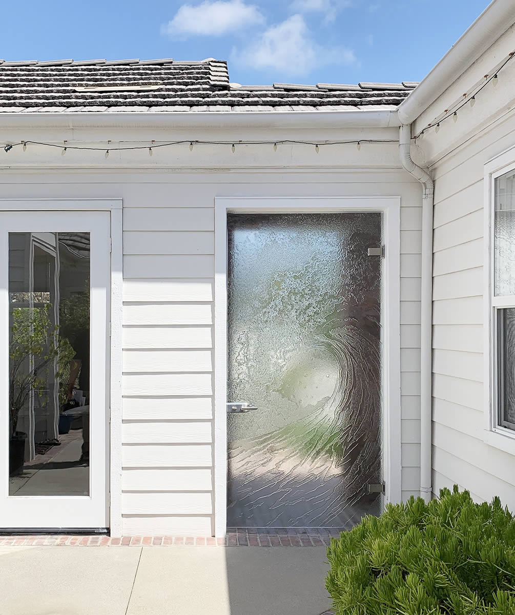 Cast glass wave door leading to a courtyard